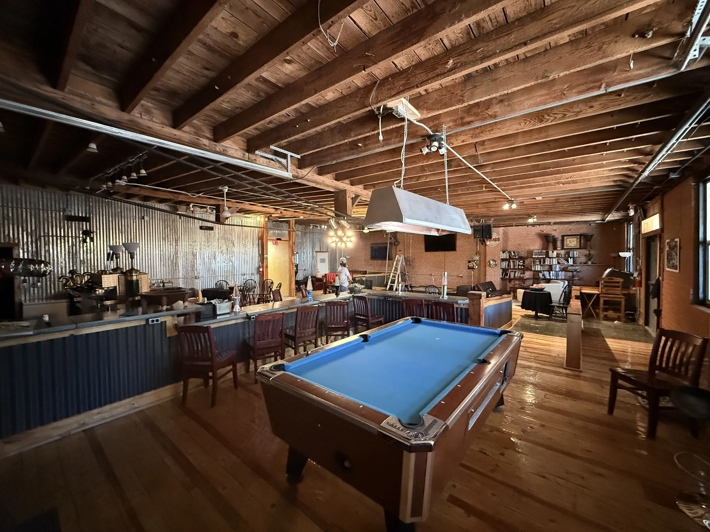 Pool table and long bar under wood beams in The Living Room